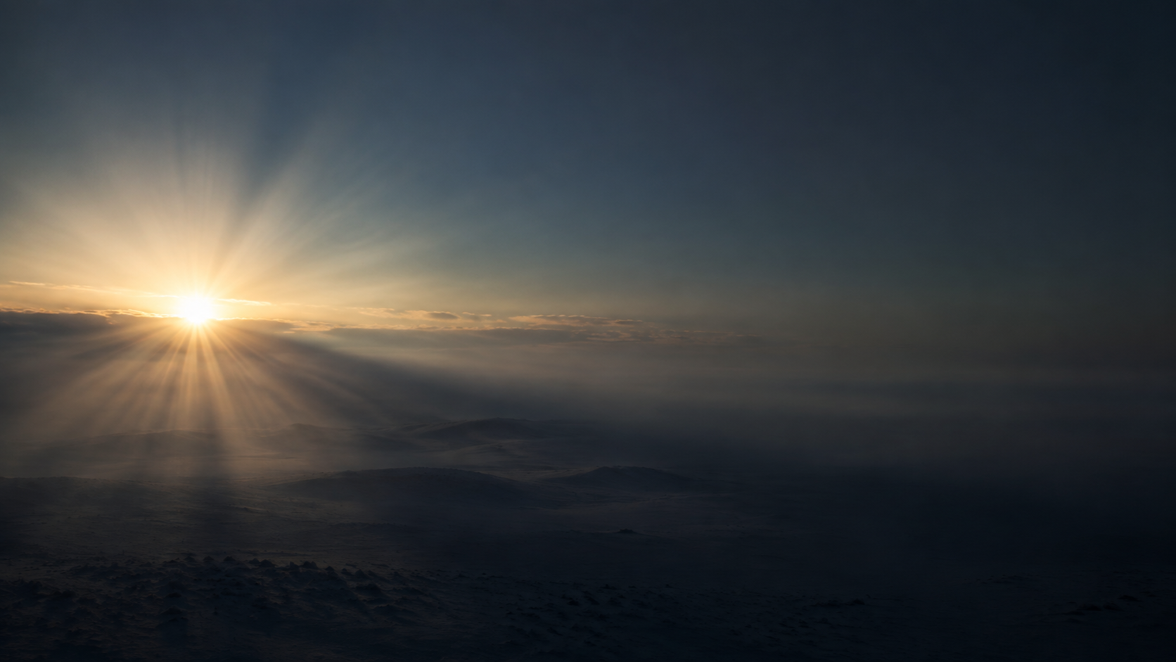 First sunlight breaking across a quiet dawn horizon